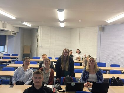 Ein Foto einer Gruppe junger Menschen, die in einem Klassenraum sitzen. 