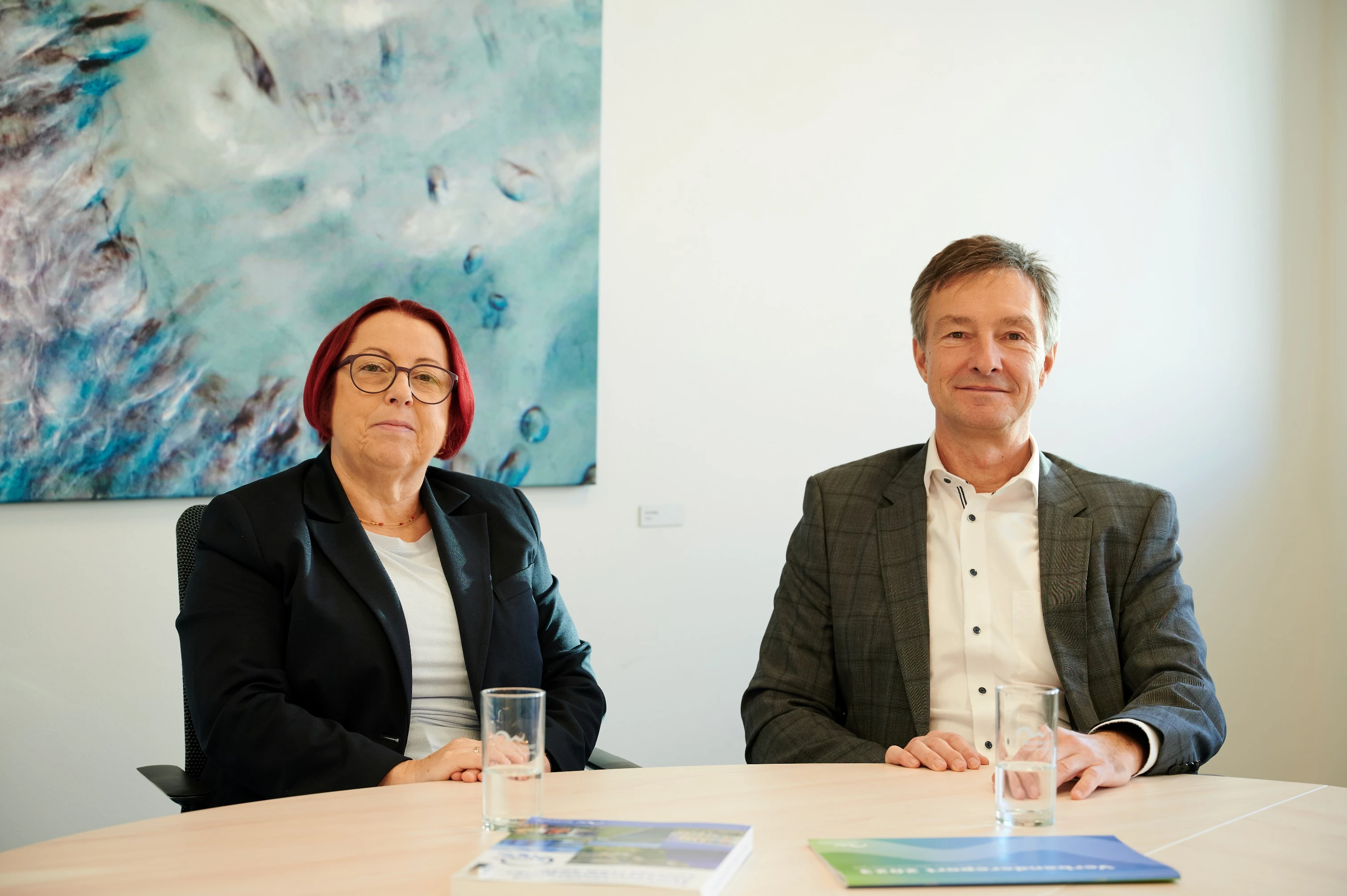 Frau Gödke und Herr Altmann sitzen an einem Tisch