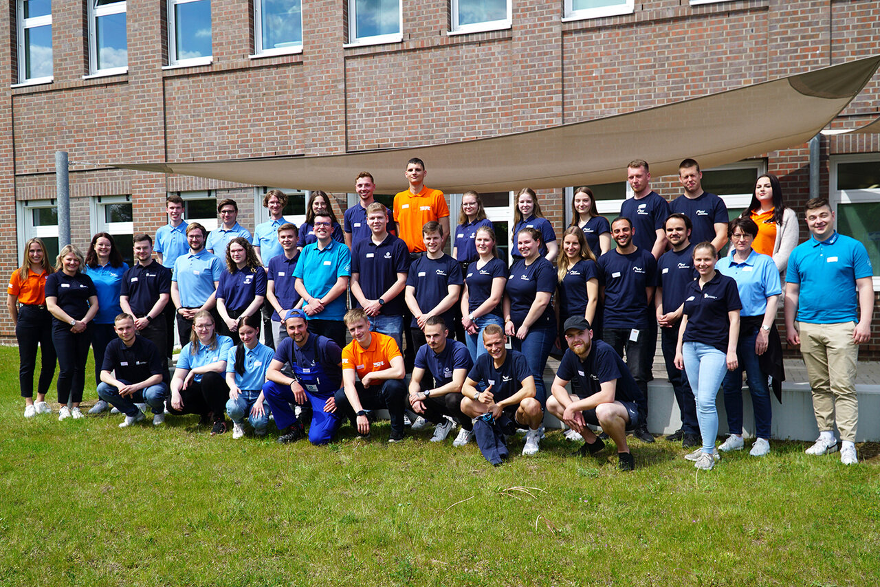 Gruppenfoto von vielen Leuten vor einem Gebäude.