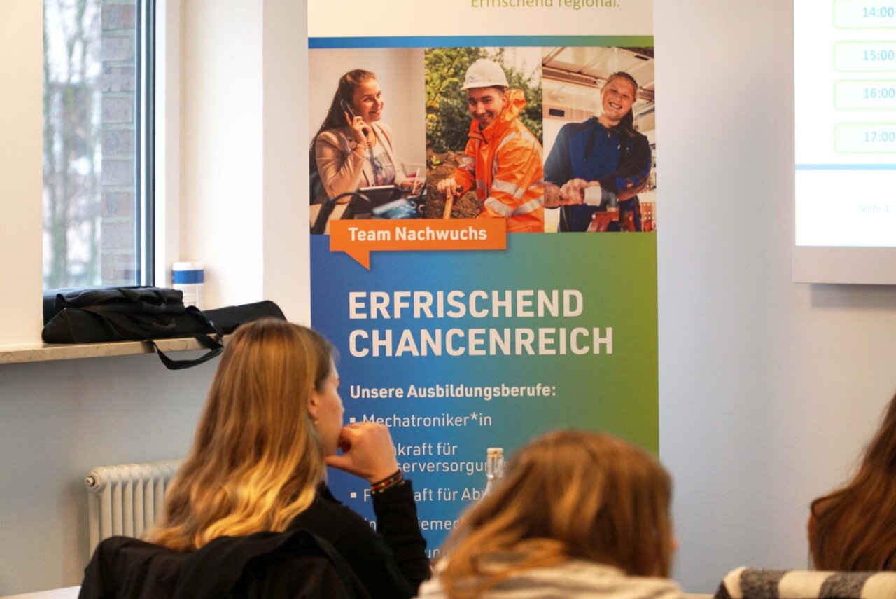 Sitzende Personen in einem Raum vor einem Nordwasser-Banner.